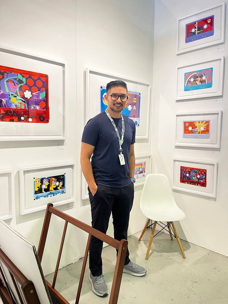 David Levitz, Los Angeles mixed media artist, standing in front of his pop art cassette framed art pieces