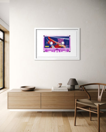 Framed artwork on a wall in a modern room with wooden furniture and a chair.